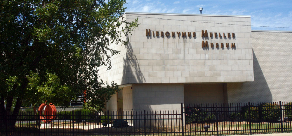 Museum_Building Front of Mueller Museum building on a sunny day behind an iron fence